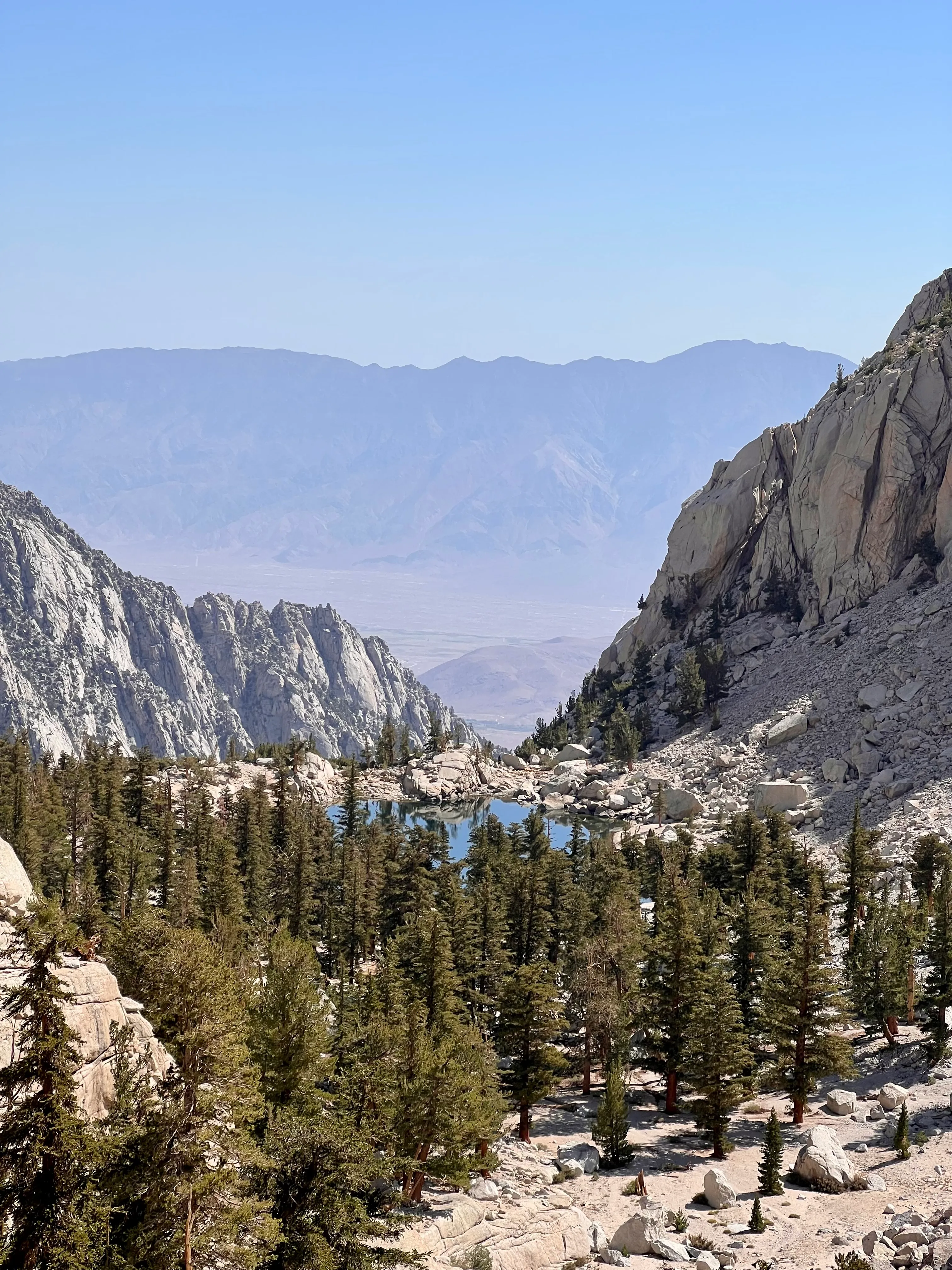 The shattered summit plateau of Mount Whitney at 14,505 feet, summit hut and storm clouds